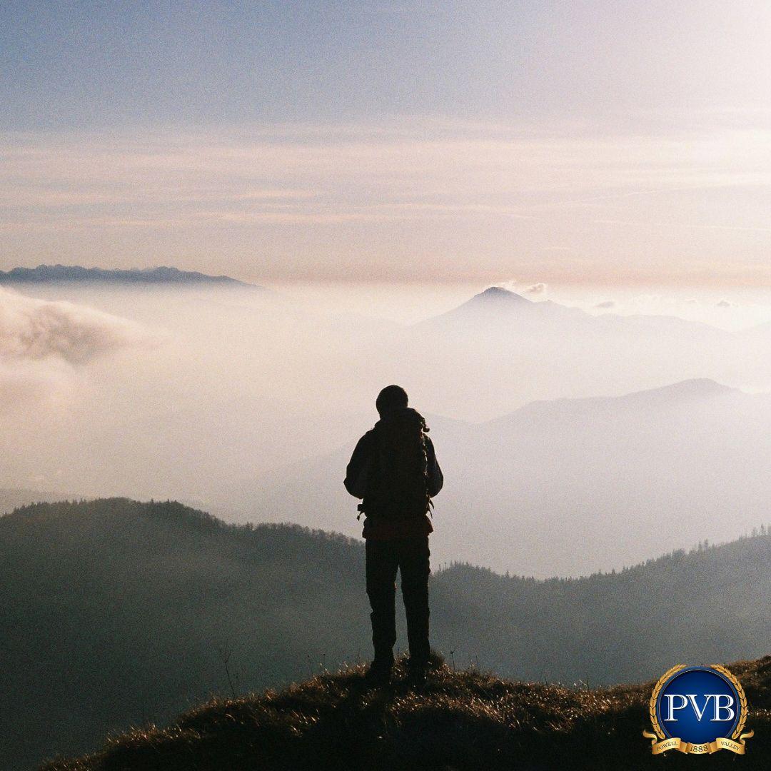 photo of man standing on mountain top